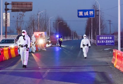 Agentes de policía con trajes protectores inspeccionan vehículos en Gaocheng este martes.
