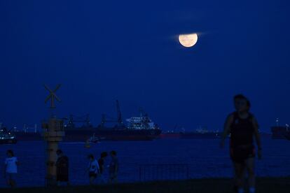 La Luna llena se eleva en Singapur, este martes.