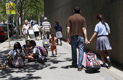 Un padre y una hija a la salida de un centro escolar.