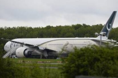 Un avión de la compañía Pakistán Internacional Airlines (PIA) permanece en el aeropuerto de Stansted, en Reino Unido, este viernes. Dos hombres fueron detenidos en el aeropuerto de Stansted, en las afueras de Londres, por poner en riesgo un vuelo de la compañía Pakistan International Airlines (PIA), que tuvo que ser escoltado por dos cazas británicos y desviado de su ruta.