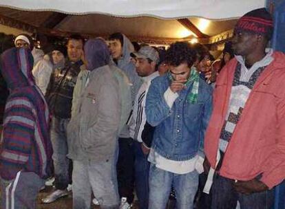 Un grupo de inmigrantes interceptados en aguas italianas espera en el puerto de Lampedusa.