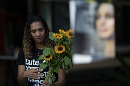 Anielle Franco holds sunflowers as she attends a memorial for her murdered sister councilwoman Marielle Franco and the driver Anderson Pedro Gomes, who both were killed a month ago in Rio de Janeiro, Brazil, Saturday, April 14, 2018. Franco's death has touched a nerve with many in a nation where more than 50 percent identify as black or mixed race, but where most politicians are white men. (AP Photo/Leo Correa)