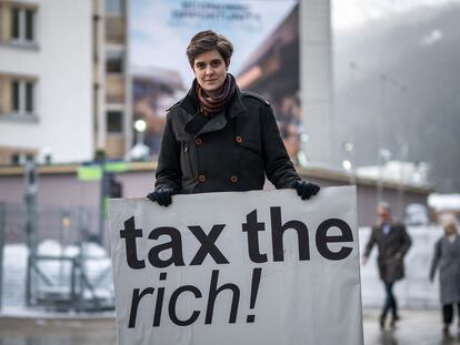 La austriaca Marlene Engelhorn, heredera de una fortuna, a la entrada del Foro de Davos con una pancarta en la que pide más impuestos para los ricos, este lunes.