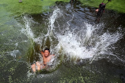 Un niño salta al agua para refrescarse en la aldea de Chuong, fuera de Hanoi, Vietnam.