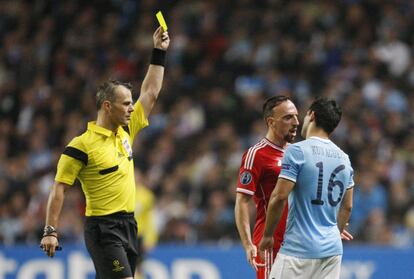 El Kun Agüero ve la tarjeta amarilla mientras se encara con Ribéry.