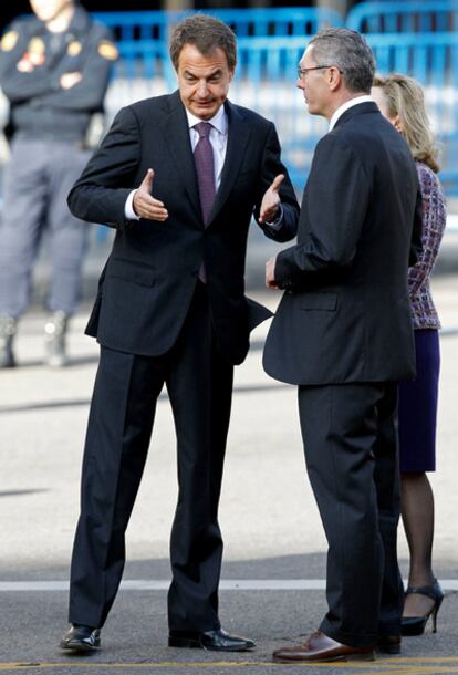 El presidente del Gobierno, José Luis Rodríguez Zapatero, y el alcalde de Madrid, Alberto Ruiz-Gallardón, discuten antes del inicio del desfile, ante la presencia de la presidenta de la Comunidad de Madrid, Esperanza Aguirre, entre otras autoridades.