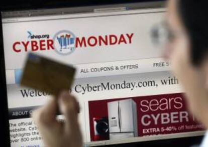 Un hombre posa con una tarjeta de crédito frente a un ordenador, durante el "ciberlunes" con ofertas en diversas tiendas online. EFE/Archivo