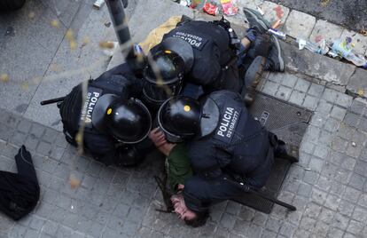 Officers from the Catalan regional police force Mossos d'Esquadra detain a man outside the headquarters of the Catalan government.  