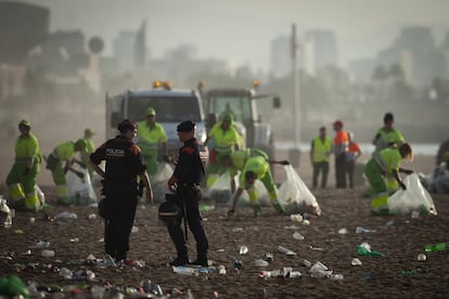 Operarios trabajan en la limpieza de las playas de Barcelona.