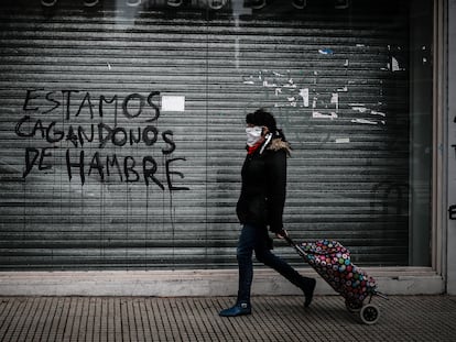 Una persona pasa frente a un comercio de la ciudad de Buenos Aires cerrado a causa de la crisis económica.