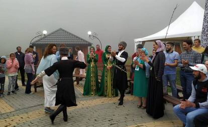 Un grupo de música tradicional canta y baila con algunos participantes de la regata Ajmát, en el lago Kezenoyam, a finales de julio.