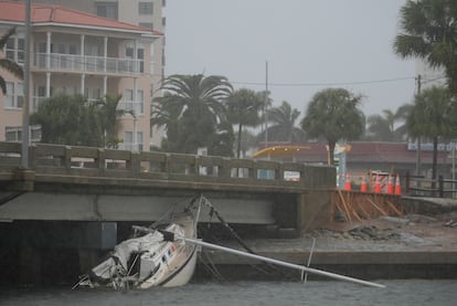 Un bote dañado tras el paso del huracán 'Helene' yace bajo un puente de Pasadena del Sur ante la llegada de 'Milton'. 