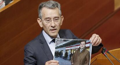 El socialista Antonio Torres muestra una foto de Rajoy durante el pleno de este jueves en las Cortes.