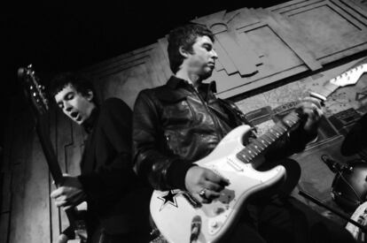 Noel Gallagher, de Oasis, junto a Mick Jones toca la guitarra.