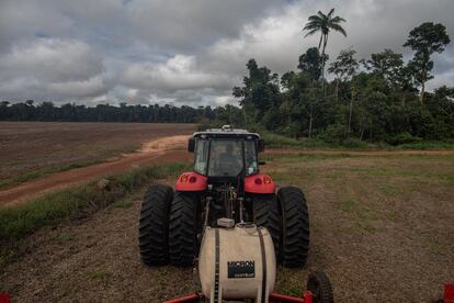 Um trator da fazenda Minuano, No fundo, uma das parcelas da vegetação que lei obriga a preservar nesta zona de Amazonia.Apenas 20% da  propriedade é de área cultiváveis.