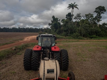 Um trator da fazenda Minuano, No fundo, uma das parcelas da vegetação que lei obriga a preservar nesta zona de Amazonia.Apenas 20% da  propriedade é de área cultiváveis.