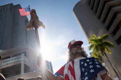 Osmany Estrada, envuelto en una bandera mitad estadounidense y mitad cubana, a las afueras de la corte de Miami.