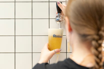 Camarera sirviendo cerveza sin filtrar en el bar Península Centro de Madrid.