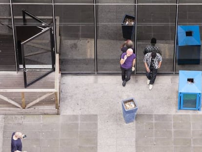 Un grupo de empleados de una oficina hace una pausa para fumar. 