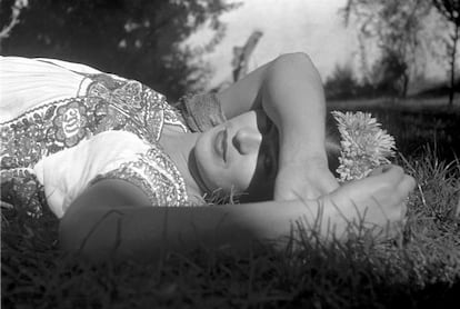 Frida Kahlo lying in a garden.