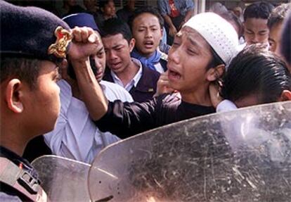 Simpatizantes del ulema Abu Bakar Bashir protestan ante un cordón policial durante el traslado del clérigo.