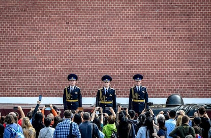 Un grupo de turistas toma fotos de los guardias de honor rusos durante la ceremonia de cambio de guardia en la Tumba del soldado desconocido, junto a las murallas del Kremlin, en Moscú (Rusia).