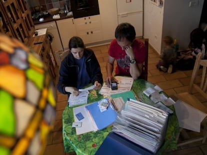 Una pareja revisa sus facturas de agua, luz y electricidad.
