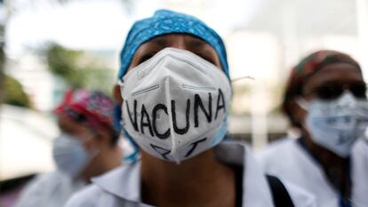 Una sanitaria usa una mascarilla que dice "Vacuna para todos" durante una protesta en Caracas, Venezuela.