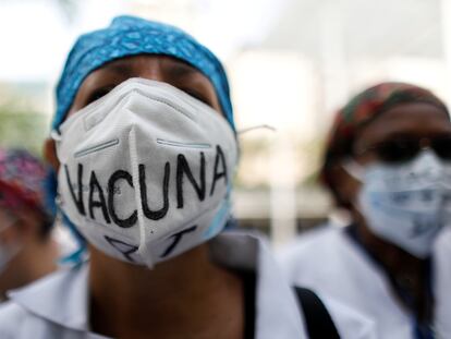 Una sanitaria usa una mascarilla que dice "Vacuna para todos" durante una protesta en Caracas, Venezuela.