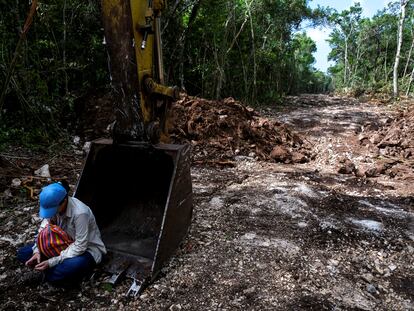 Una activista se sienta sobre maquinaria para evitar que continúe trabajando en la construcción del tramo 5 del "Tren Maya", en Akumal, Estado de Quintana Roo (México), el 2 de agosto.