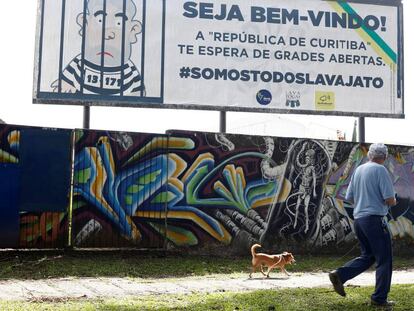 Un hombre camina junto a un cartel que caricaturiza a Lula encarcelado, ayer en Curitiba.