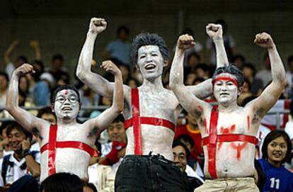 Tres aficionados japoneses, disfrazados de bandera danesa.