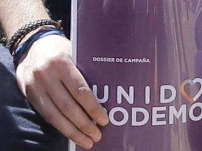 El l&iacute;der de Podemos, Pablo Iglesias, sostiene el dossier de campa&ntilde;a con el logo de Unidos Podemos.