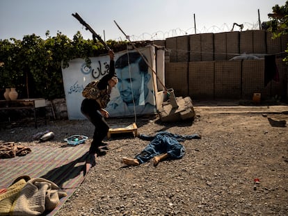 Un soldado afgano golpea el cuerpo sin vida de un talibán ametrallado, en Kandahar el 10 de agosto.