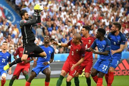 Rui Patricio portero de Portugal, detiene un balón en presencia de los delanteros de Francia y defensas de su equipo.