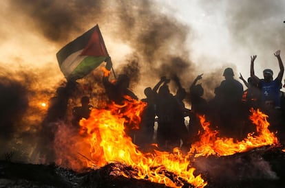 Un manifestante palestino ondea una bandera nacional durante una protesta en la frontera marítima con Israel.