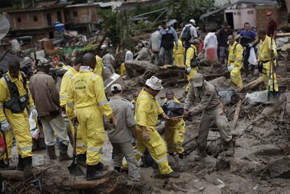 Más de 1.000 hombres trabajan en las tres ciudades con un aspecto desolador, muy parecido a la devastación de un terremoto, con barrios enteros caídos al suelo y convertidos en lagos de agua y fango. En la imagen, los trabajadores rescatan uno de los cadáveres que permanecía en una de las zonas arrasadas.