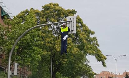 El muñeco de un policía municipal colgado de un semáforo.