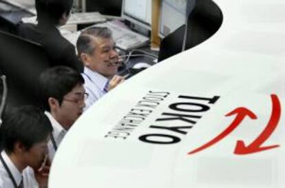 Trabajadores de la bolsa de Tokio trabajan frente a sus monitores en el parqué de Tokio.