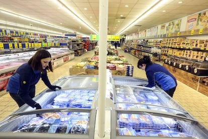 Dos empleadas reponen productos en las neveras de un supermercado de Lidl en Madrid