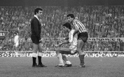 Tello (Betis) levanta Antonio Álvarez ante la presencia de Enríquez Negreira en el Sevilla - Betis (1-1) de la temporada 1981/82.