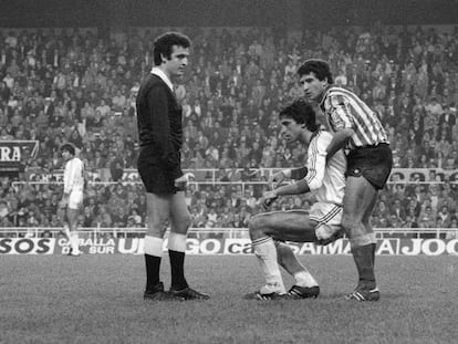 Tello (Betis) levanta Antonio Álvarez ante la presencia de Enríquez Negreira en el Sevilla - Betis (1-1) de la temporada 1981/82.