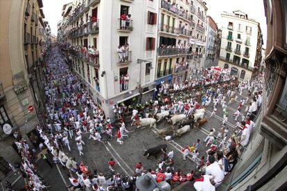 Los mozos corren, en la calle Estafeta, delante de los toros de la ganader&iacute;a de Torrestrella (C&aacute;diz) que han protagonizado el quinto encierro de los Sanfermines.
 