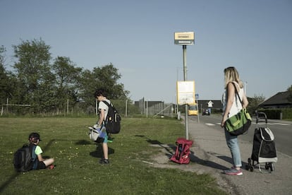 La familia espera al transporte escolar de los pequeños.
