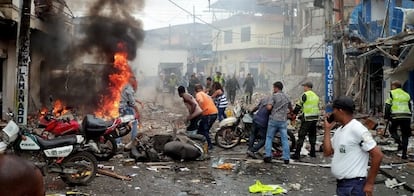 Un grupo de personas, ante el lugar en el que explotó una bomba en Tumaco (Colombia).