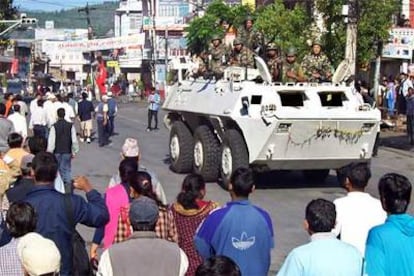 Decenas de manifestantes violan el toque de queda ante la mirada atenta y actitud alerta de soldados nepalíes.