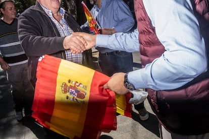 Reparto de banderas por parte de Vox en la calle Mayor de Alcorcón.
