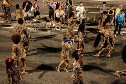 Transéuntes observan el paso de las integrantes trans de la escuela de samba Paraíso do Tuiuti durante el ensayo del carnaval.