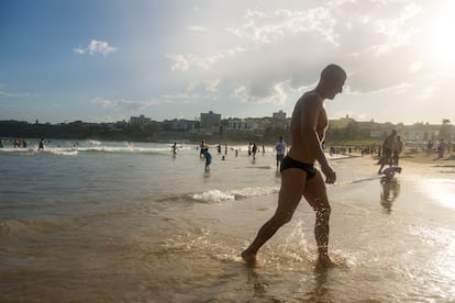 Un hombre sale del agua en una playa de Sydney.