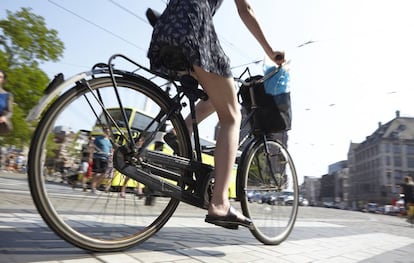 Mujer pedaleando en Ámsterdam, en Países Bajos.